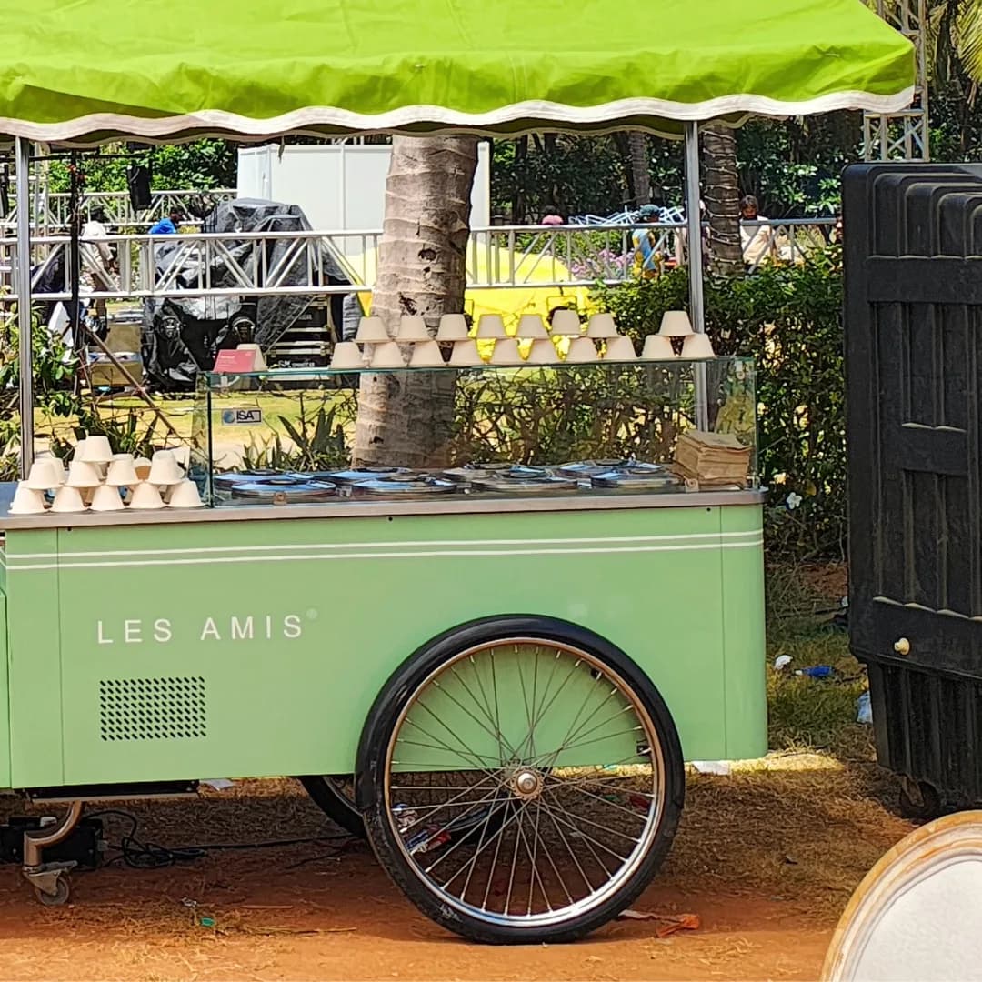 The mint-green Les Amis gelato cart with its scalloped canopy at an outdoor event