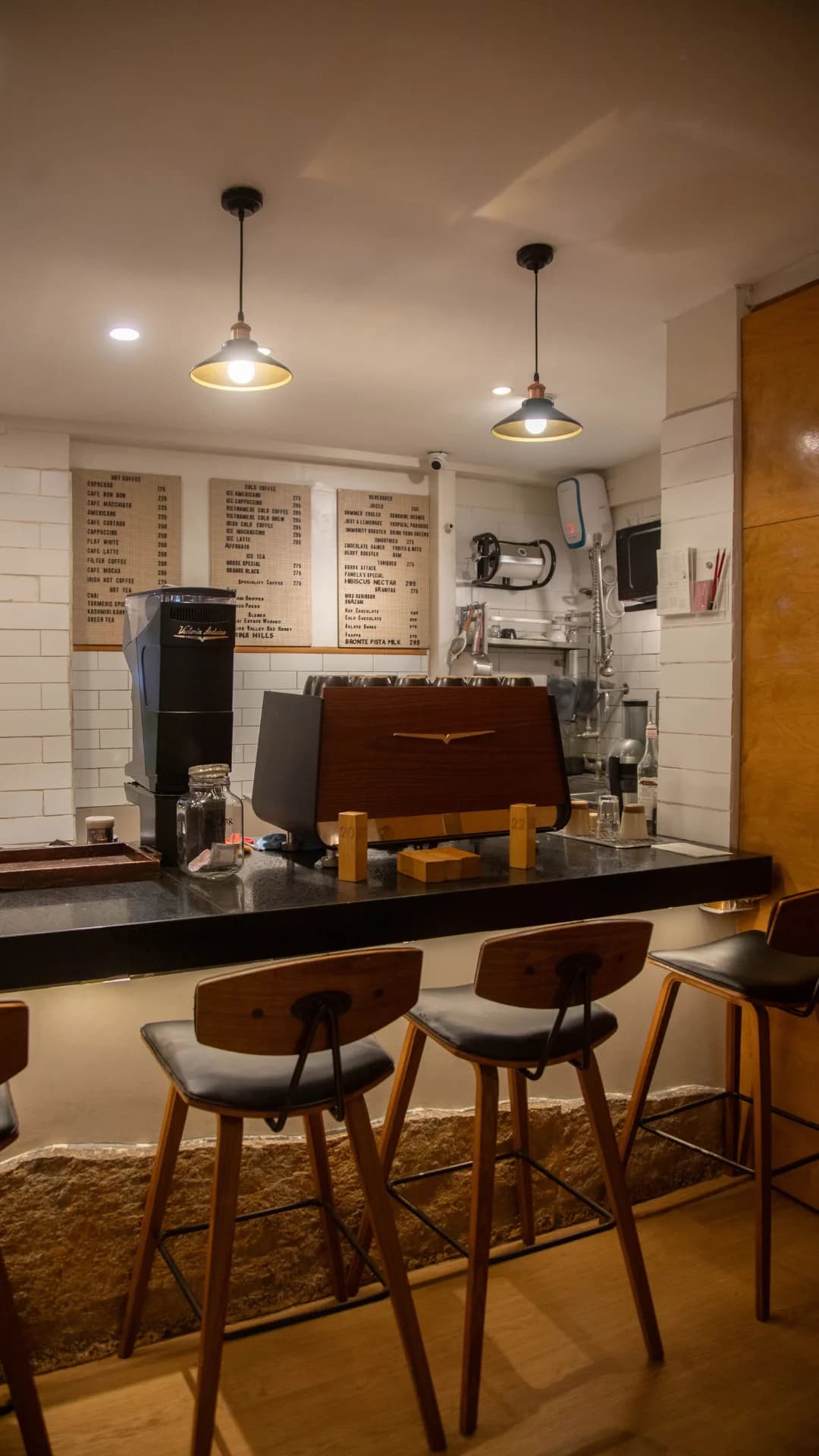 The brew bar counter with stools and the menu boards above